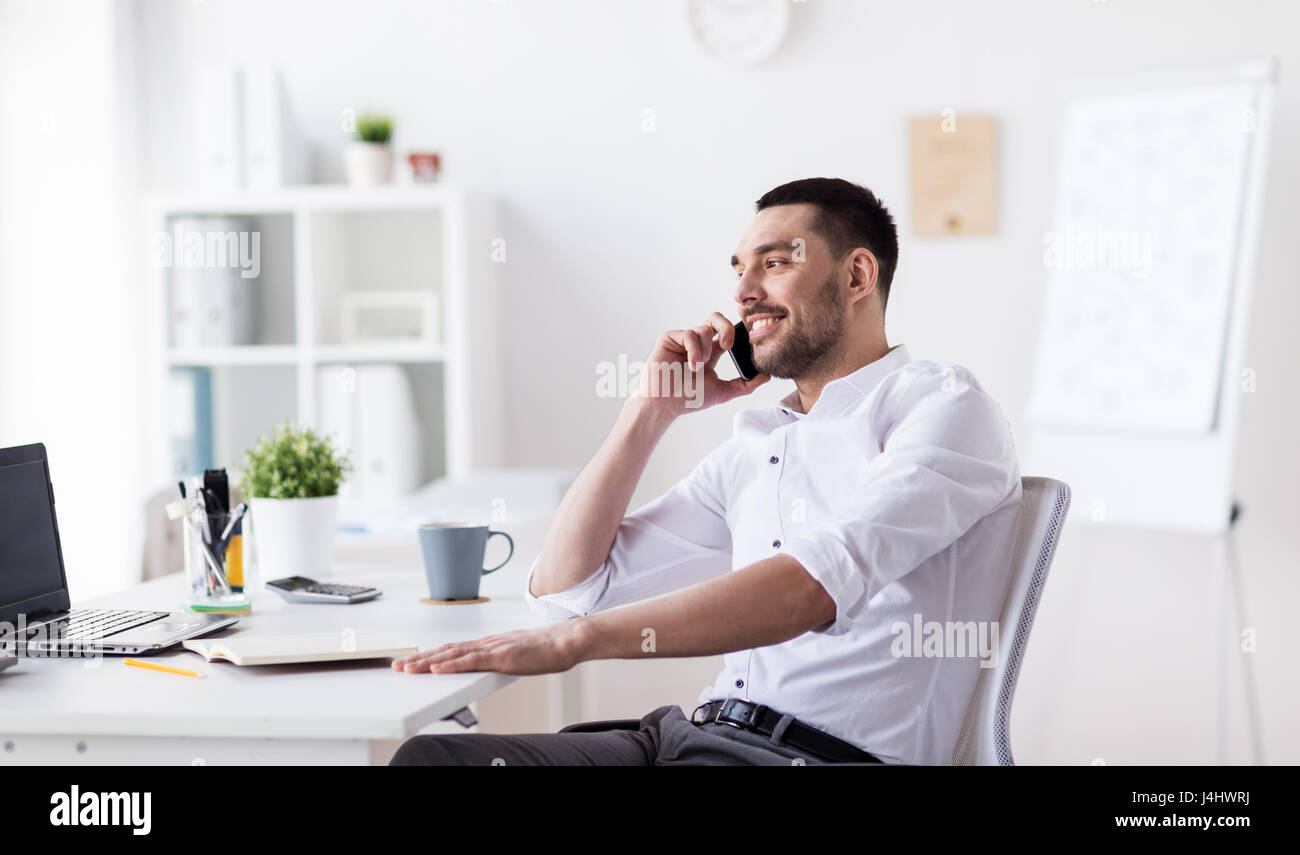 Imprenditore chiamando sullo smartphone in ufficio Foto Stock