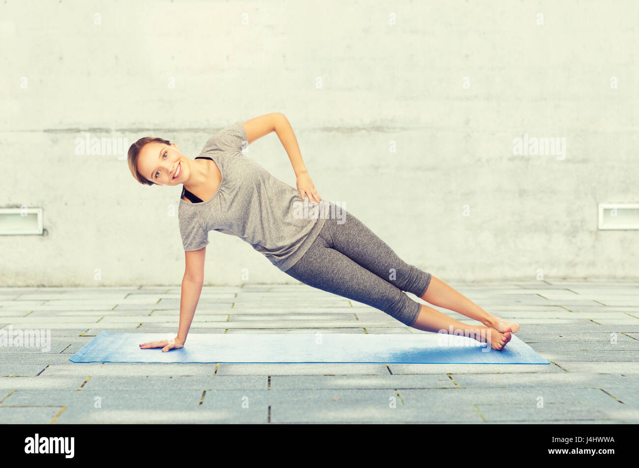 Donna fare yoga nella posizione del cobra pone sul tappeto Foto Stock