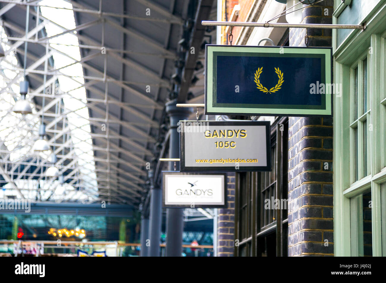 Negozio di fronte segni in Spitalfields Market, London, Regno Unito Foto Stock