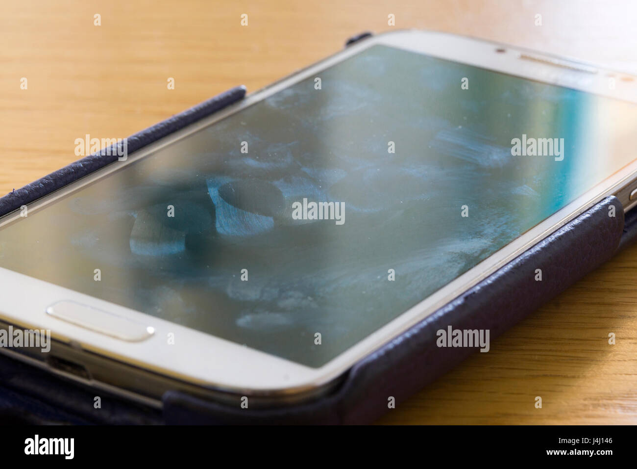 Un primo piano su un schermo smartscreen che mostra macchie e impronte digitali Foto Stock