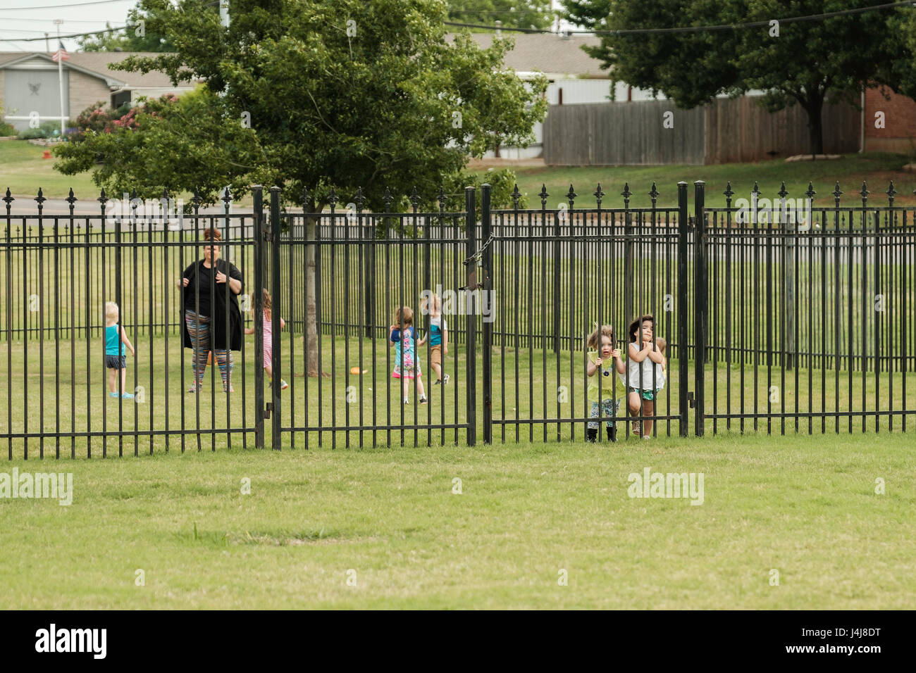 I bambini giocano nell'area recintata di un centro di assistenza nella città di Oklahoma, Oklahoma, Stati Uniti d'America. Foto Stock
