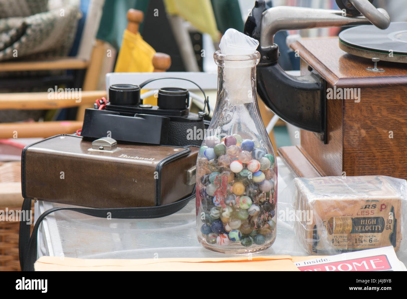 Vecchia fotocamera stereo, fonografo e una bottiglia di marmi in fiera antiquaria. Foto Stock