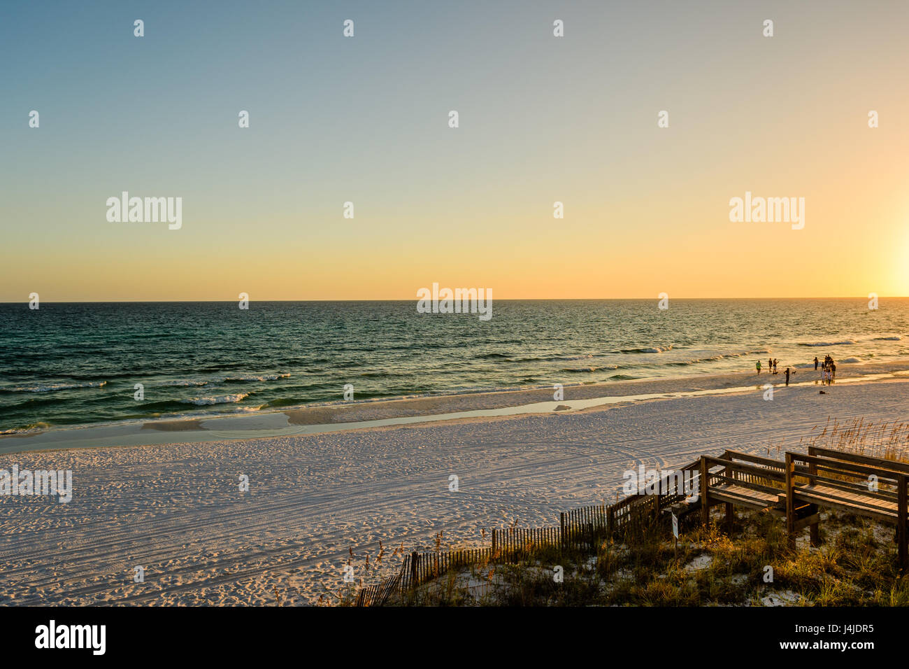 Persone che camminano su una spiaggia della costa del golfo della Florida vicino a Destin, Florida USA, al tramonto. Foto Stock