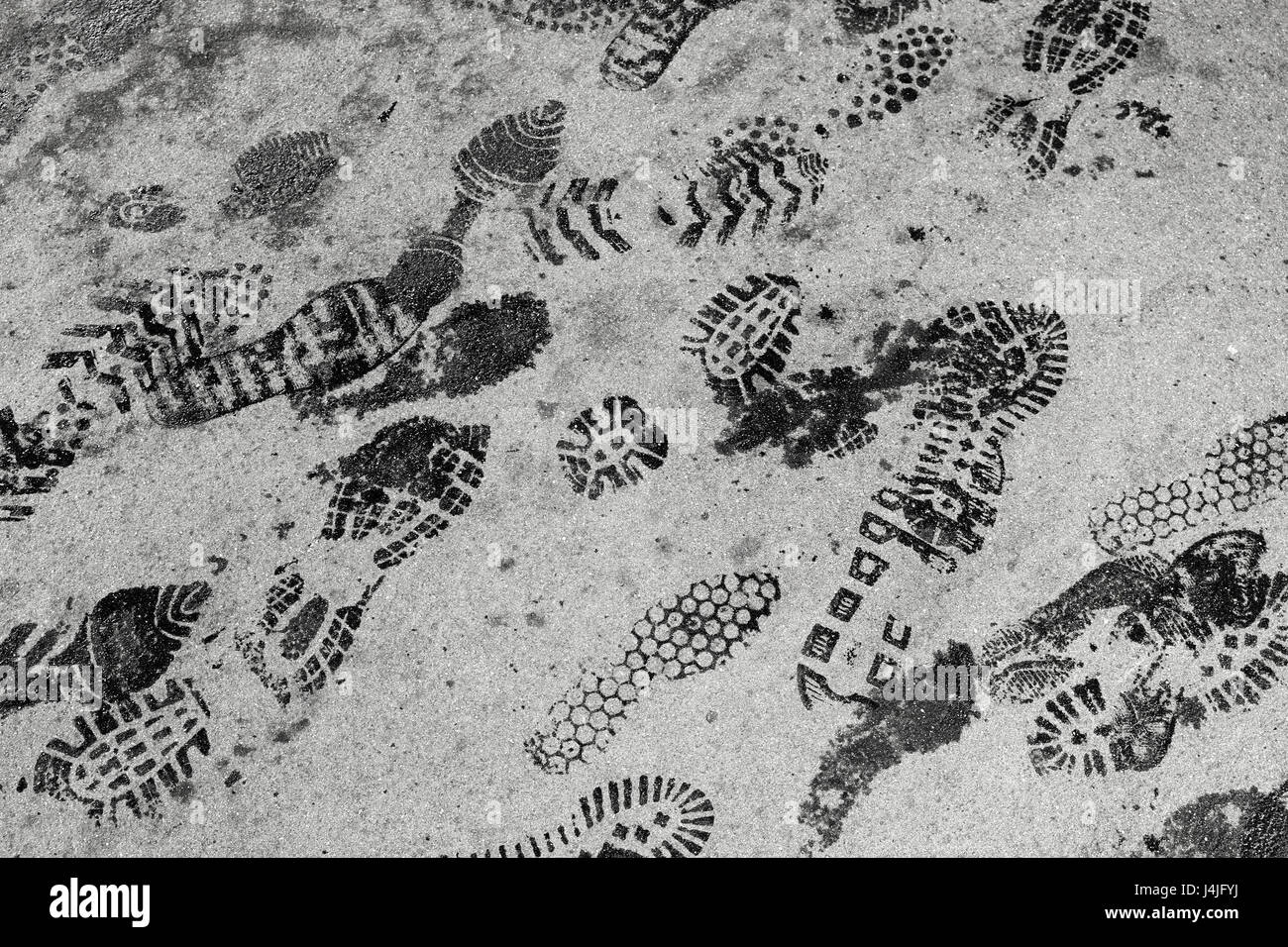 Nero con footprint di bagnato sulla pedonale GRIGIO ASFALTO Foto Stock