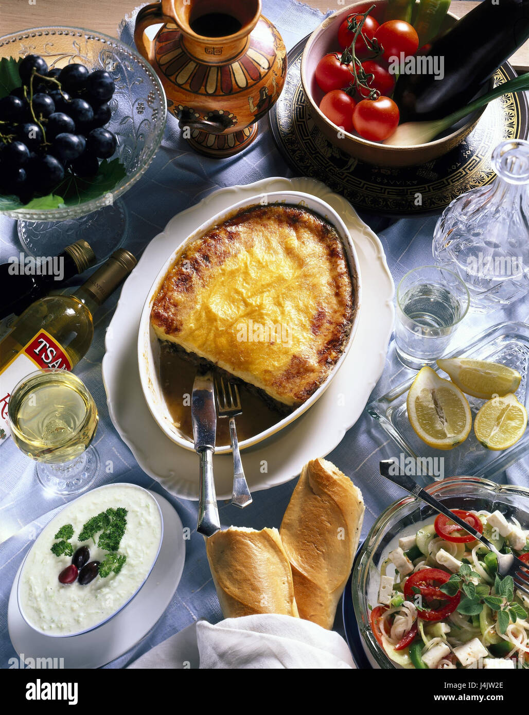 Piatti e bevande, in greco, specialità still life, oggetto fotografia, alimenti,, moussaka, tzatziki, tzatziki, baguette, insalata, uva, bere schnapps, boccette, alcol e bevande alcoliche Foto Stock