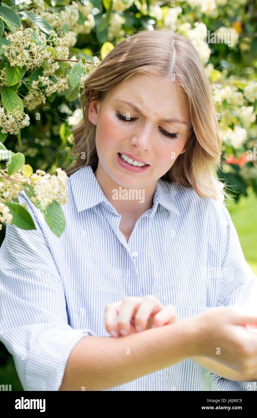 Giovane donna di albero braccio di graffiatura. Foto Stock