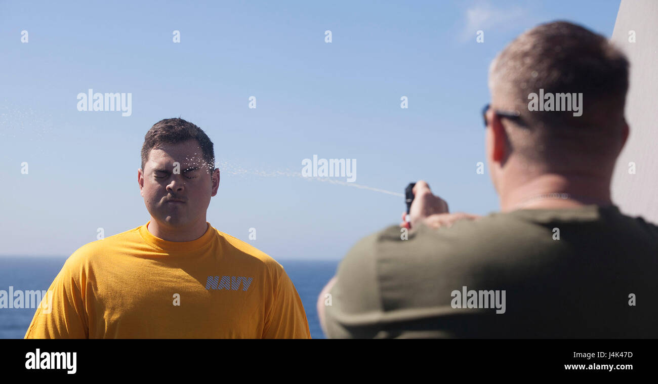 Gunnery Sgt. Arvin L. Manning, personale Sottufficiale in carica della XXIV Marine Expeditionary Unit di applicazione della legge di distacco, espone Ensign JP Morillo alla Oleoresin Capsicum spray come egli esegue una fiducia nel corso master per la formazione di armi a bordo della USS Mesa Verde (LPD) 19 Marzo 9, 2017. Il corso è impostato per migliorare un marinaio è la sua capacità di reagire a situazioni di violenza mentre colpite da O.C. Il ventiquattresimo MEU è attualmente in corso con il Bataan anfibio gruppo pronto a sostegno di le operazioni di sicurezza marittima e di teatro la cooperazione in materia di sicurezza gli sforzi nella sesta flotta area di responsabilità. (U.S. Ma Foto Stock