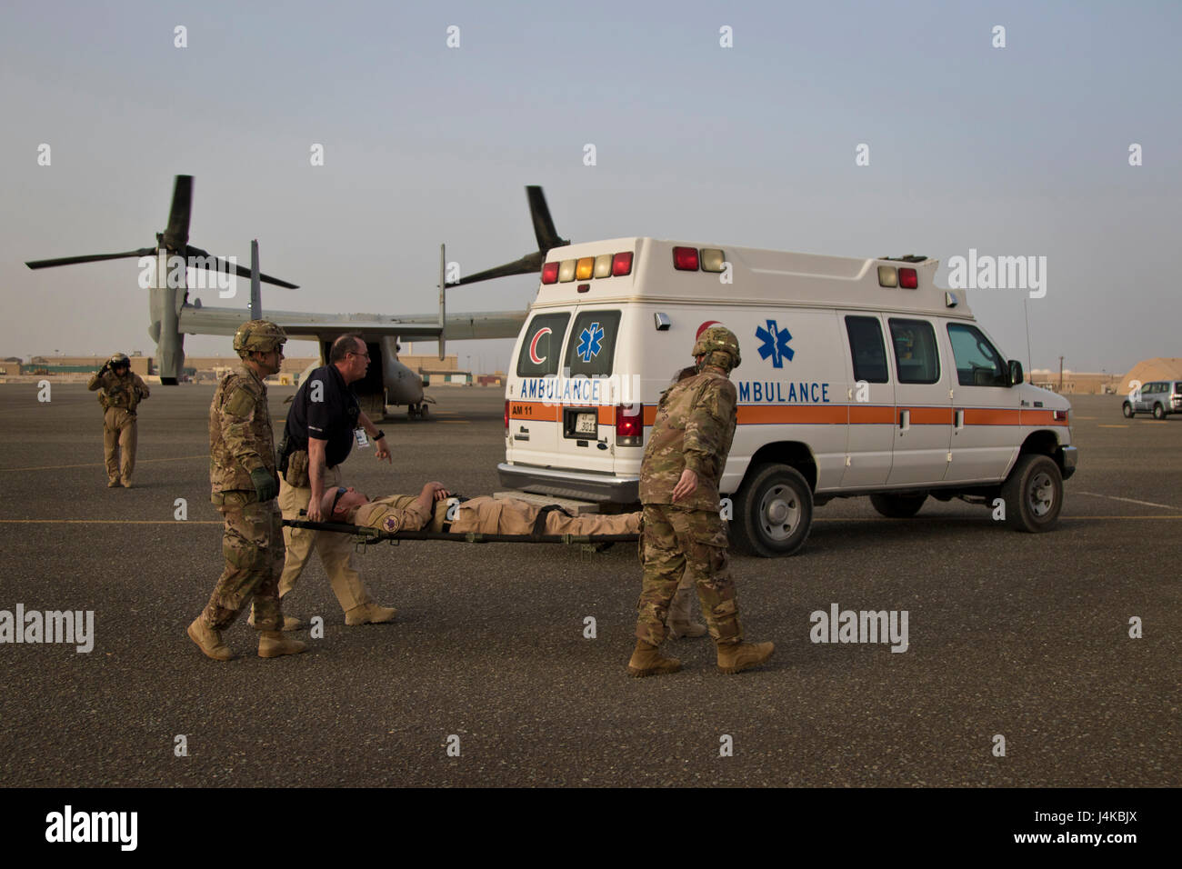Stati Uniti Army combat medics, con la 86combattere ospedale di supporto e di assistenza medica di emergenza tecnici, con area Support Group - Kuwait comune servizio di emergenza, eseguire una simulazione di incidente off di un MV-22 Osprey durante una formazione congiunta di esercitare con Marines dal mezzo marino Tiltrotor squadrone - 364 (VMM-364), a Camp Arifjan, Kuwait, 8 maggio 2017. (U.S. Foto dell'esercito da Staff Sgt. Dalton Smith) Foto Stock