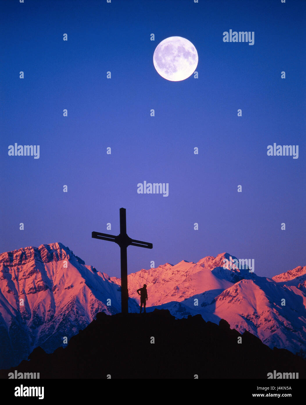 Austria, Tirolo, Karwendelgebirge, nord catena, Rumerspitze, vertice di croce, persona, luce della sera, luna piena Europa, alpi, montagne, il paesaggio di montagna, montagne Karwendel, cima, nevoso, mountain summit, 2453 m, Croce, uomo, alpinista, silhouette, neve, serata tuning, tramonto, cielo blu, senza nuvole, luna, tuning, sera invernale, [M] Foto Stock