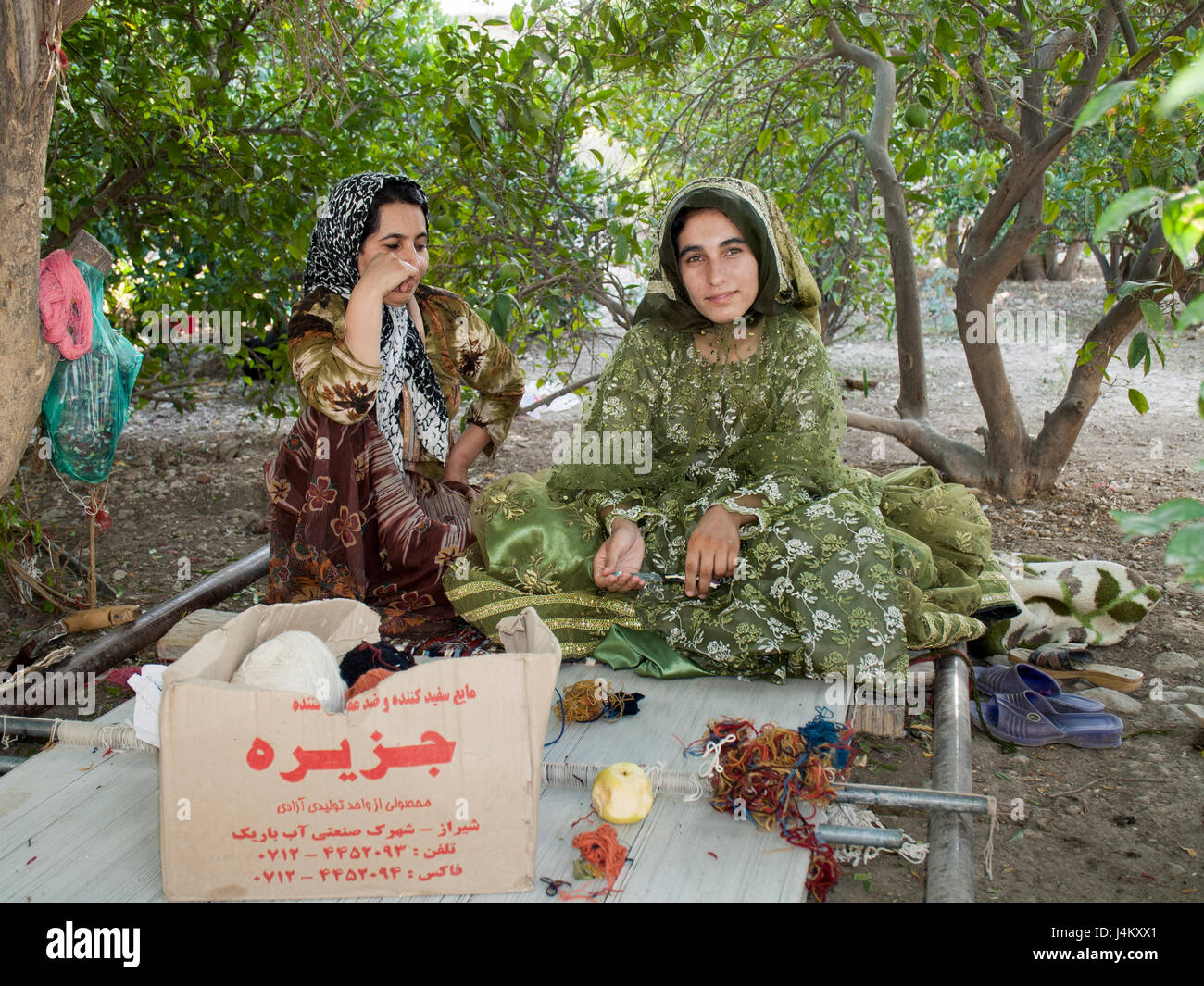Qashqai sorelle nomadi tessono un tappeto sul pavimento telaio vicino a firuzabad, Iran Foto Stock