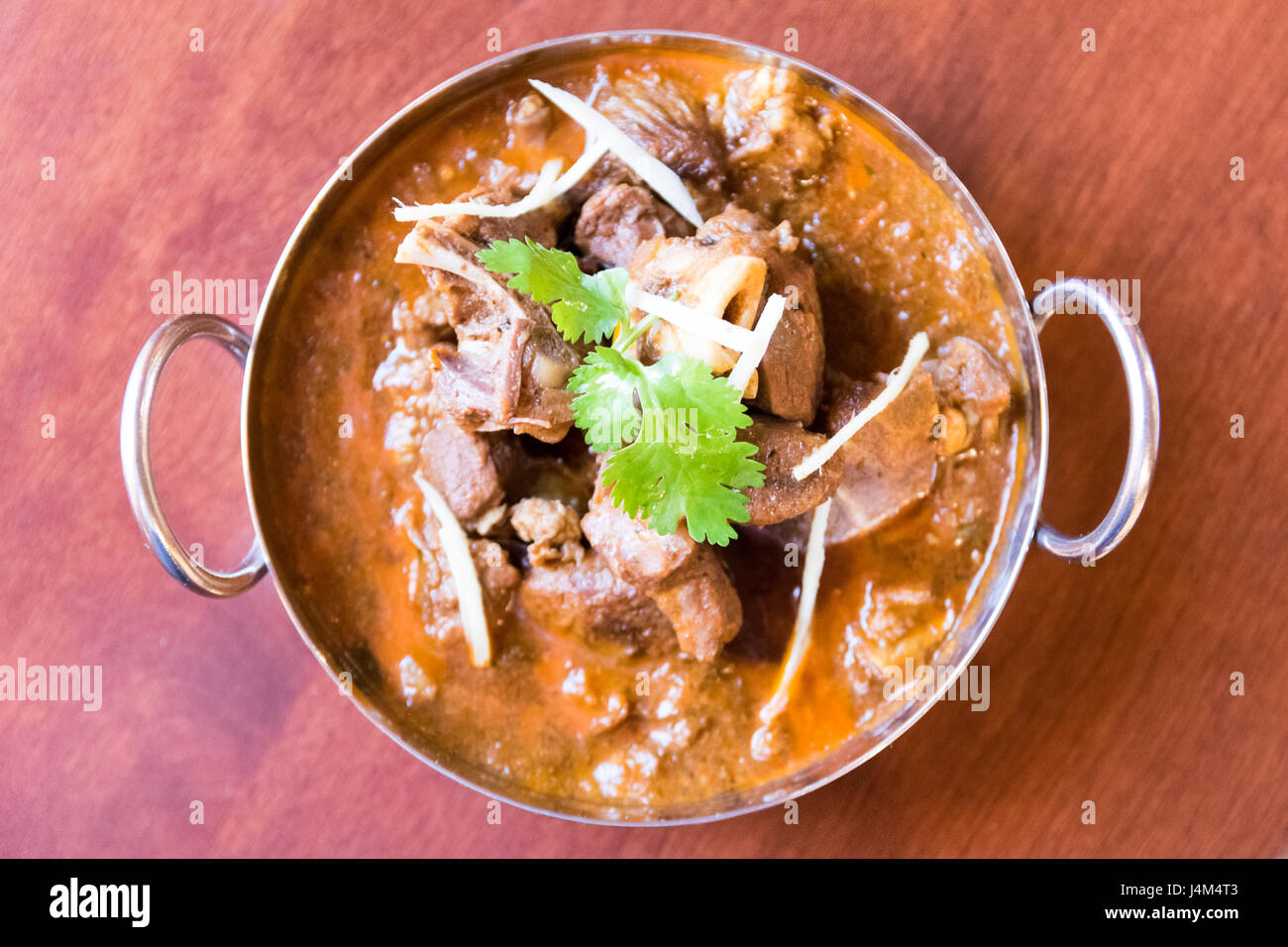 Un montone di capra curry rosso preparato in acciaio tradizionale/recipiente di ottone. Foto Stock