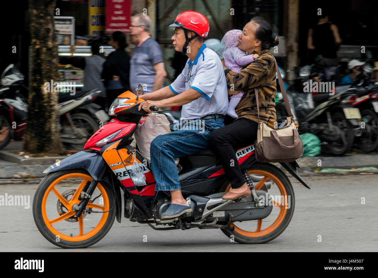 Motociclista bambino portando Hanoi Vietnam Foto Stock