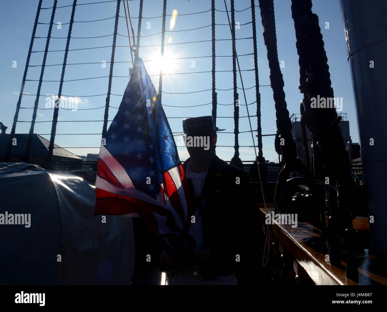 BOSTON (GEN. 21, 2017) di Boatswain Mate 2a classe Michael San Germain in posa per una foto prima che egli di paranchi a bandiera che è stato acquistato da un visitatore a bordo di vecchie Ironsides. Il morale, il benessere e la ricreazione comitato vende bandiere e il comando challange monete a bordo della nave durante gli orari di visita. (U.S. Navy Foto di artigliare il compagno del 3° di classe Erin giovenco/rilasciato) Foto Stock