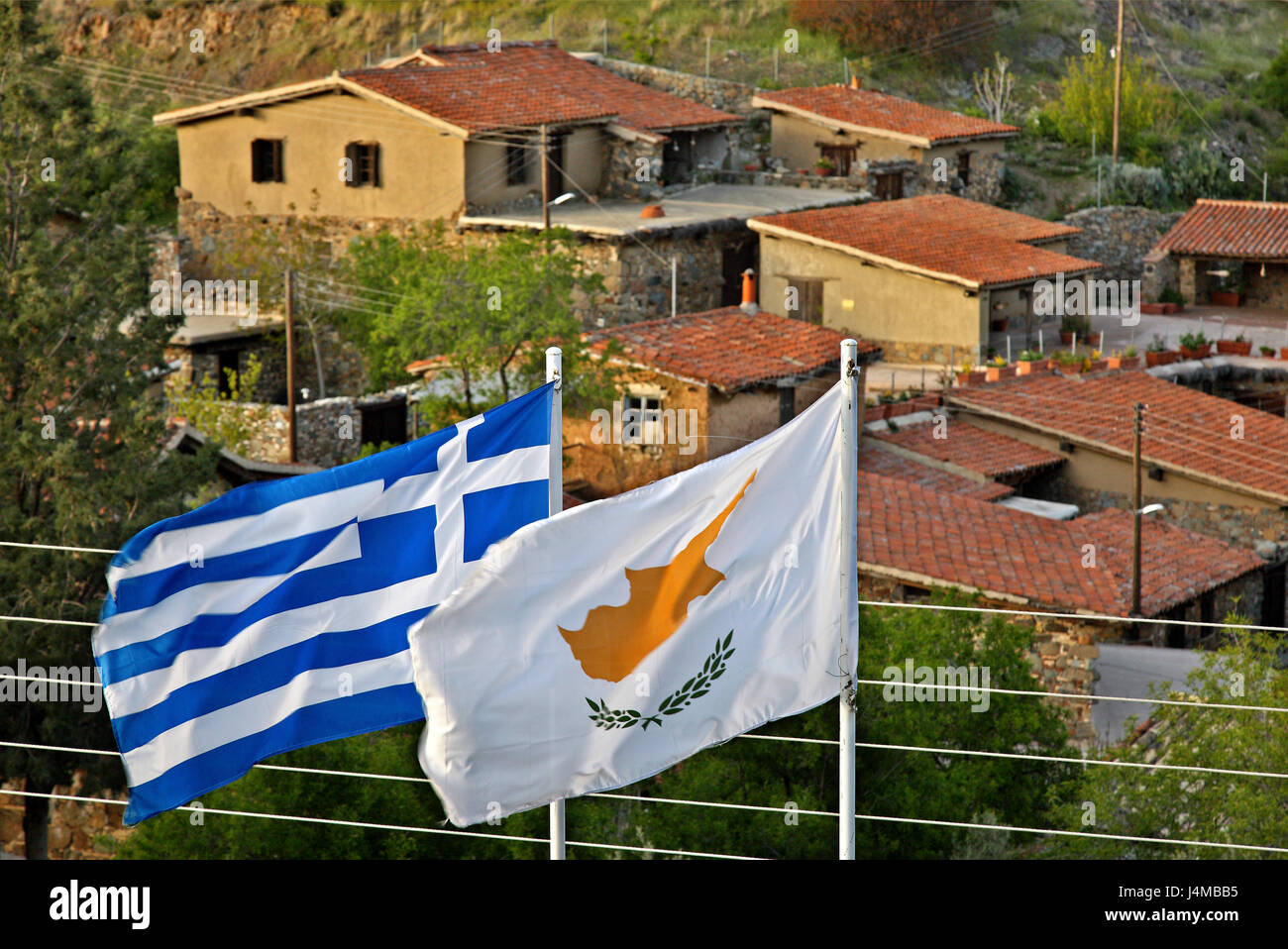 Greco e bandiera cipriota, fianco a fianco a Fikardou village, uno dei più belli villaggi di montagna di Cipro, Nicosia (Lefkosia) distretto. Foto Stock