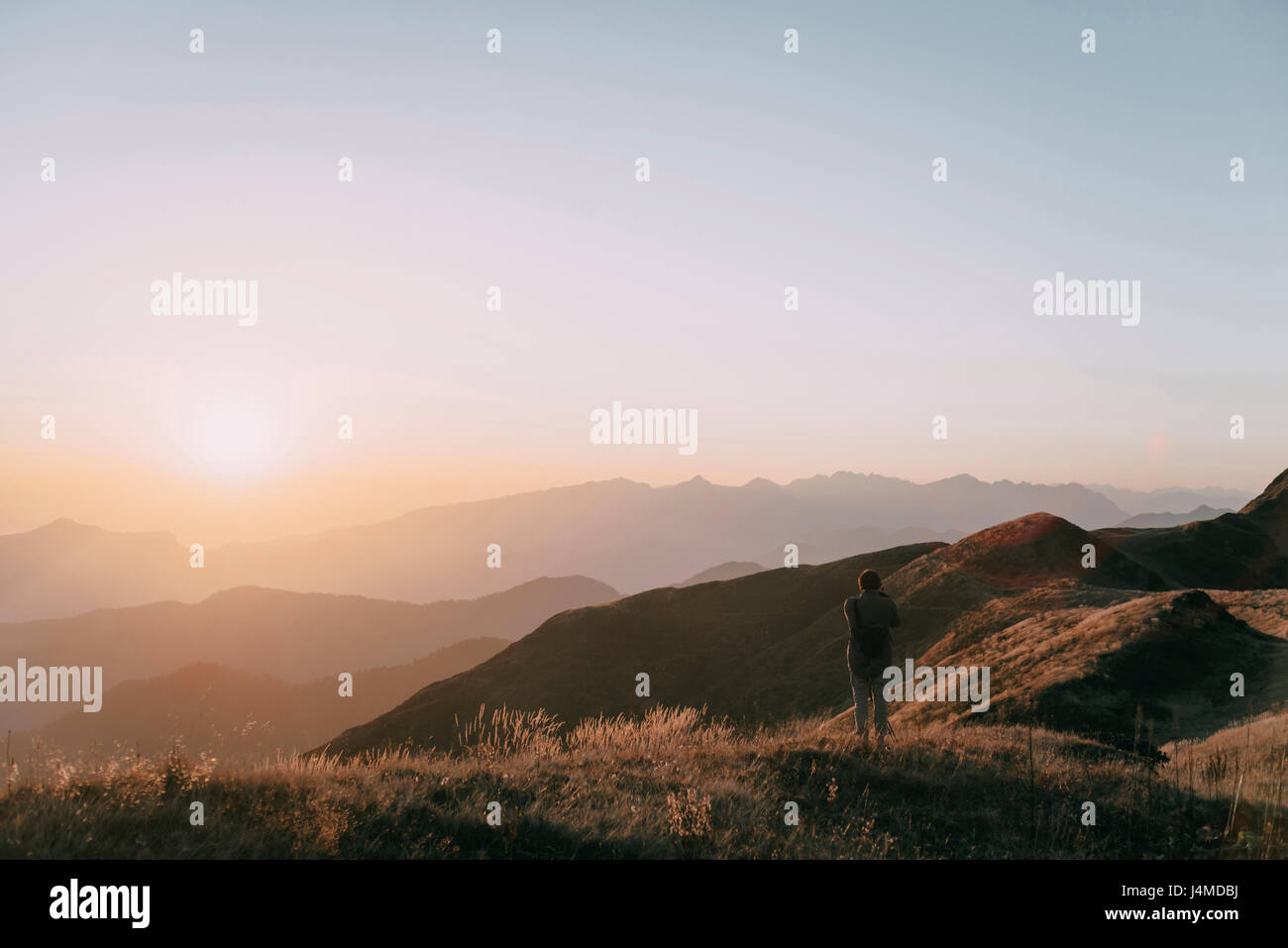 Uomo caucasico ammirando scenic la vista del tramonto sul Monte Foto Stock