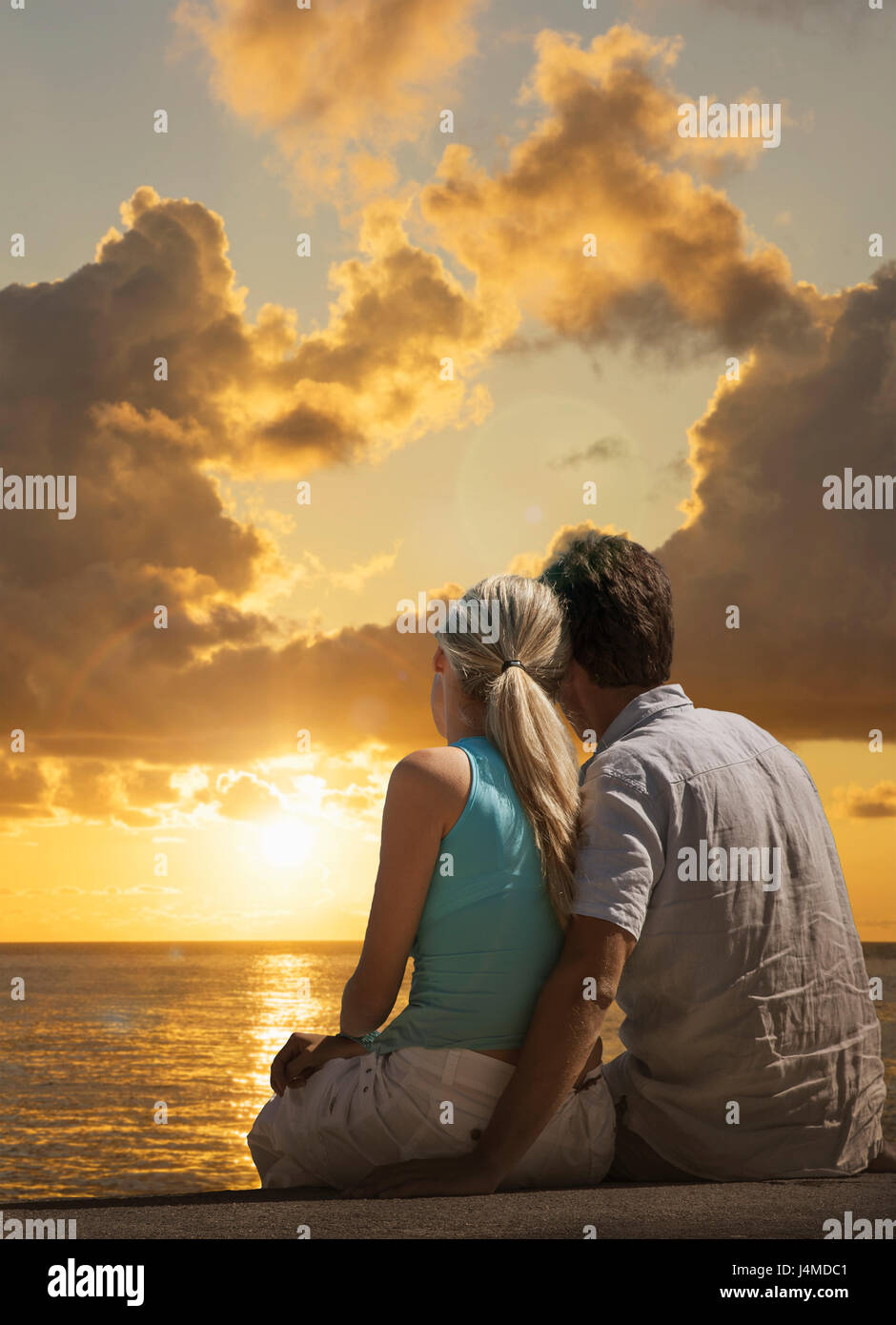 Coppia caucasica ammirando scenic vista del tramonto al mare Foto Stock