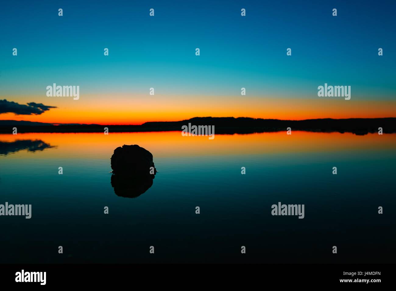Bella dopo il tramonto fotografia su un lago tranquillo a Seattle, WA con il rosso arancione tramonto Cielo di post-incandescenza si riflette nelle acque ancora. Foto Stock