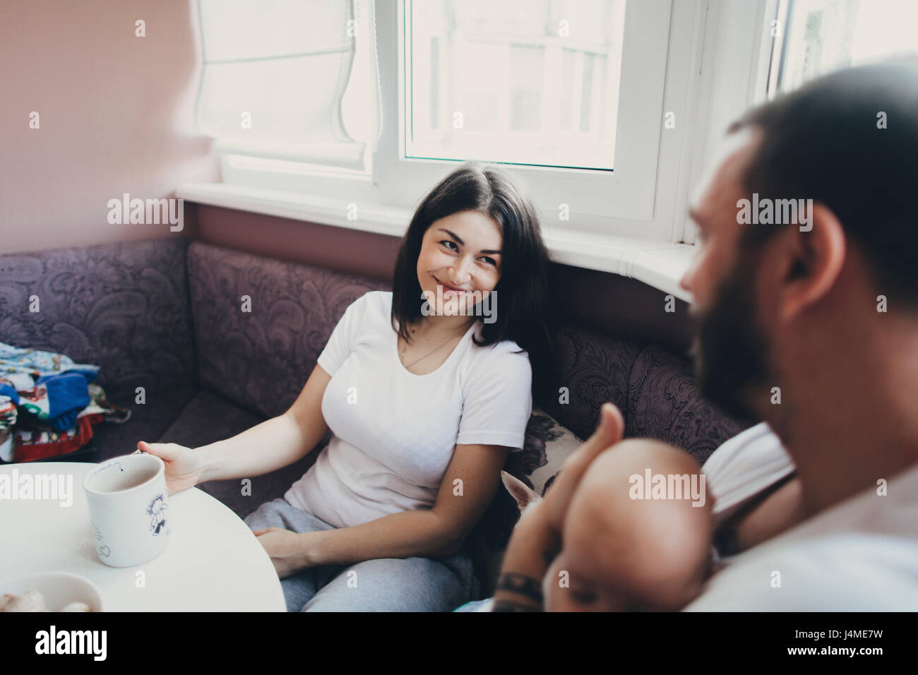 Caucasian madre e figlia seduta a tavola con baby figlio Foto Stock