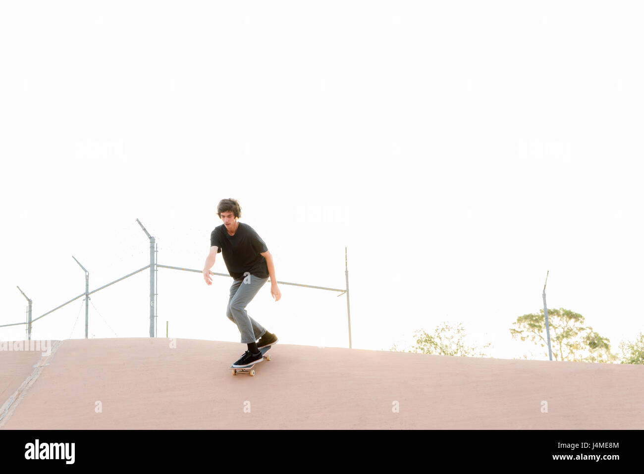 Uomo ispanico skateboarding in skate park Foto Stock