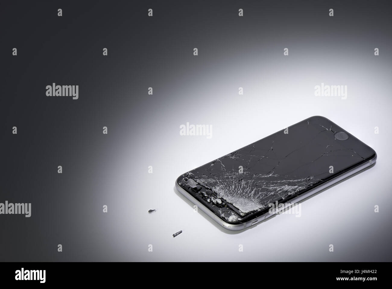 Un telefono cellulare con schermo rotto su un gradiente dello sfondo Foto Stock