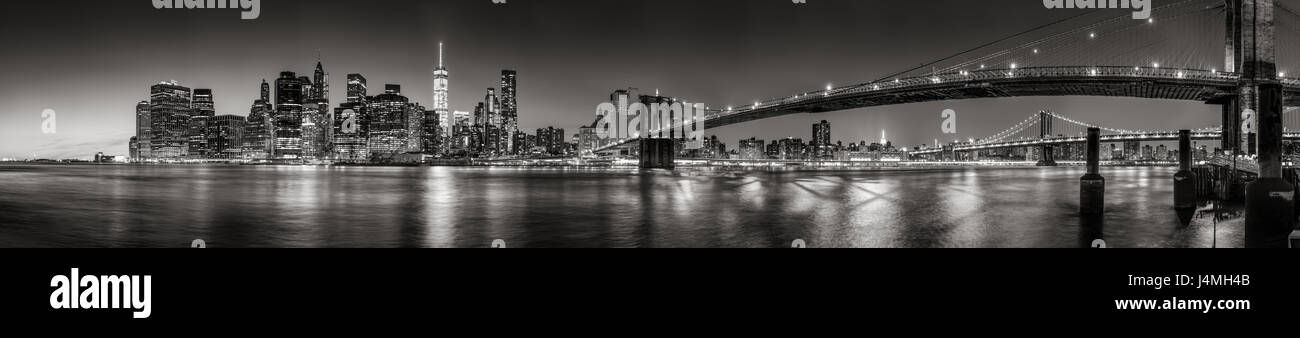 Vista panoramica in bianco e nero vista di Lower Manhattan Financial District grattacieli al crepuscolo con il ponte di Brooklyn e la East River. La città di New York Foto Stock