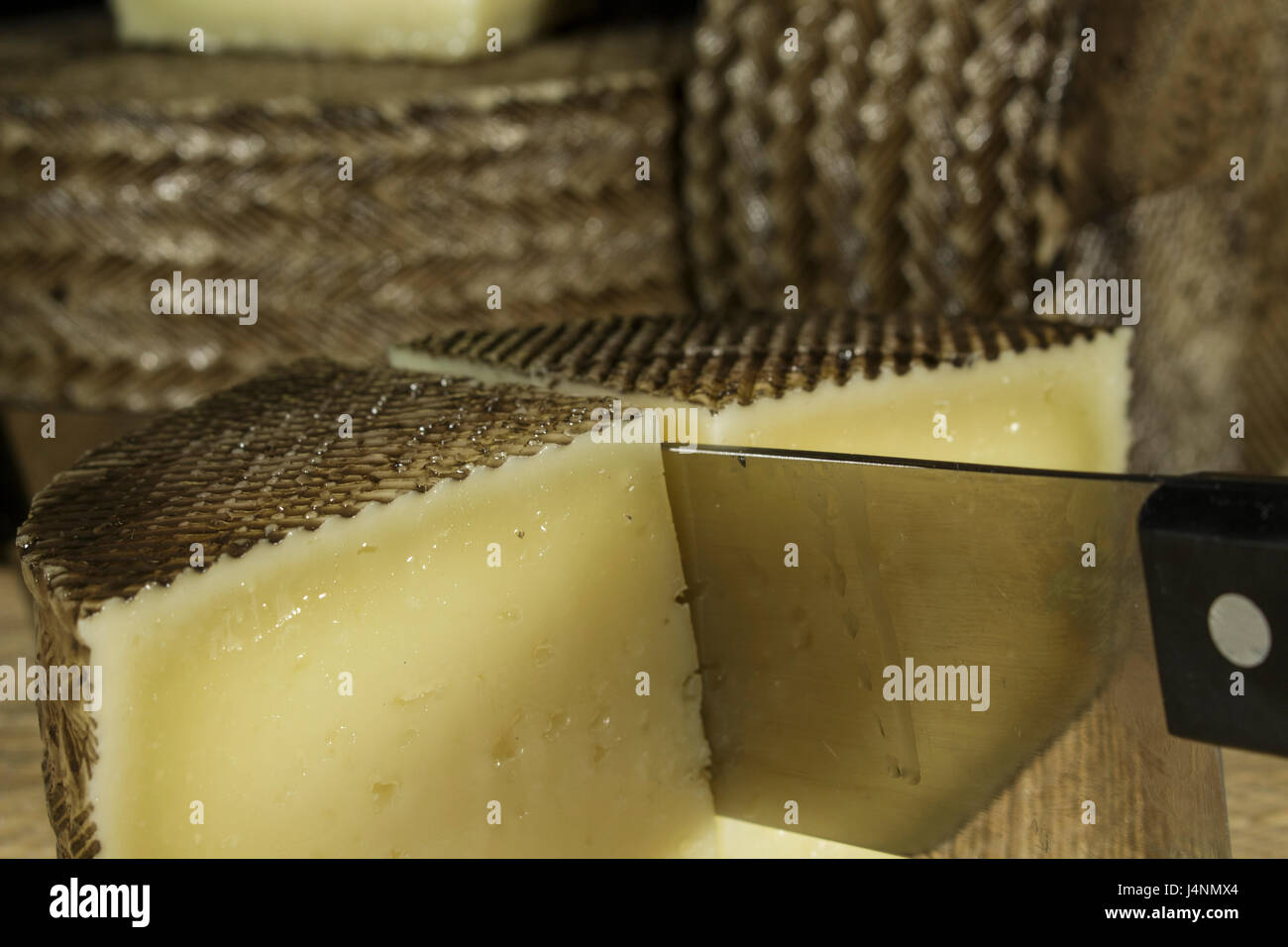 Dettaglio del Coltello per formaggio mentre taglio Formaggio Manchego Foto Stock