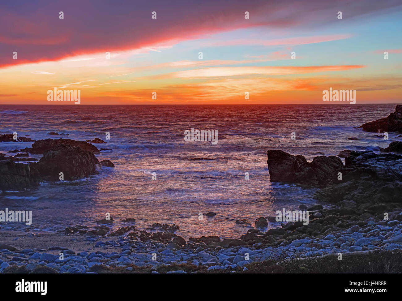 Immagine hdr di drammatiche nuvole al tramonto sulla sabbia e rocce di Asilomar membro Beach in Pacific Grove sulla penisola di Monterey in California Foto Stock