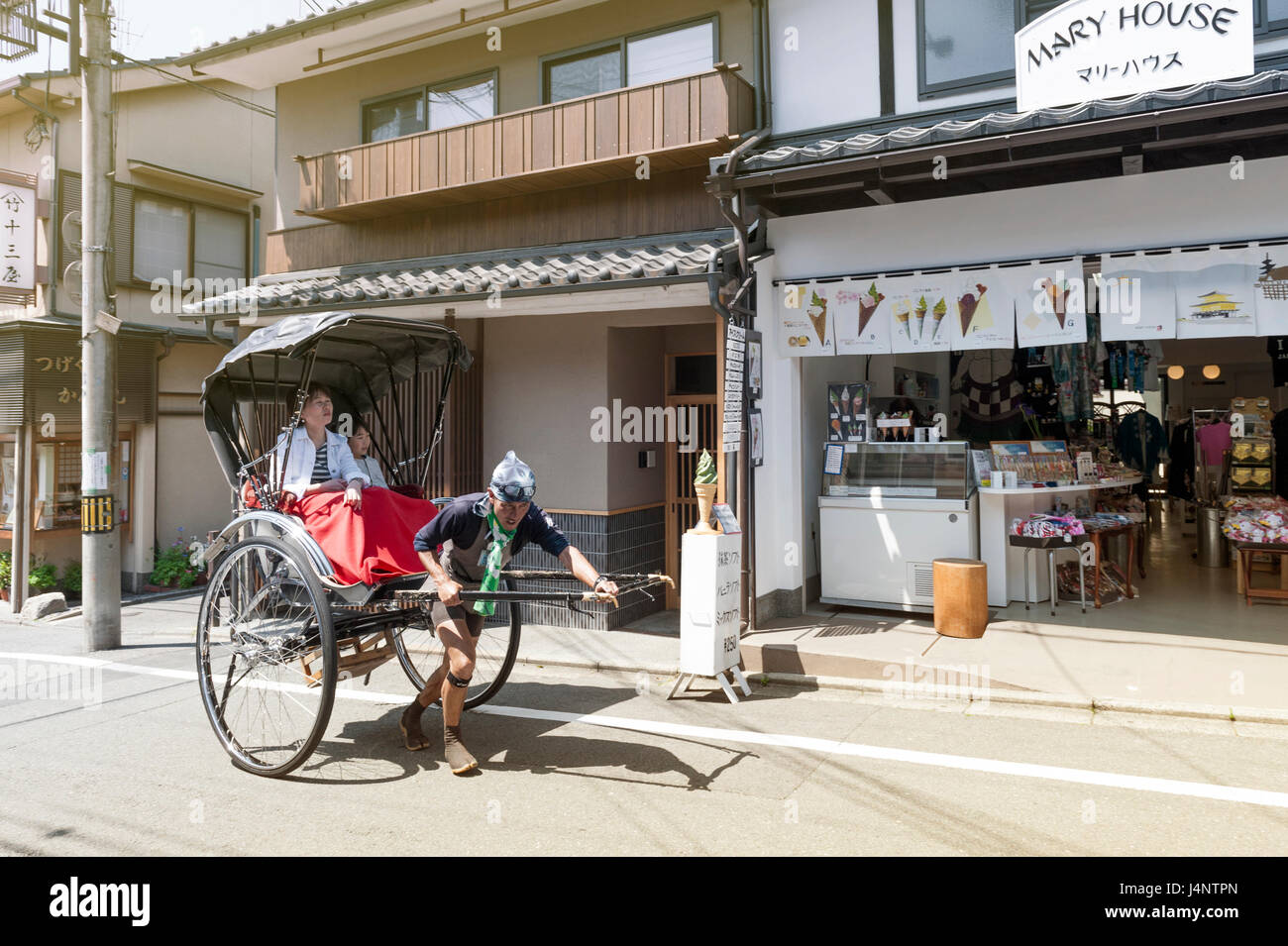 Kyoto, Giappone - Marzo 2016: Giapponese tradizionale tirata a mano rickshaw che trasportano i turisti su Matsubara street a Kyoto, Giappone Foto Stock