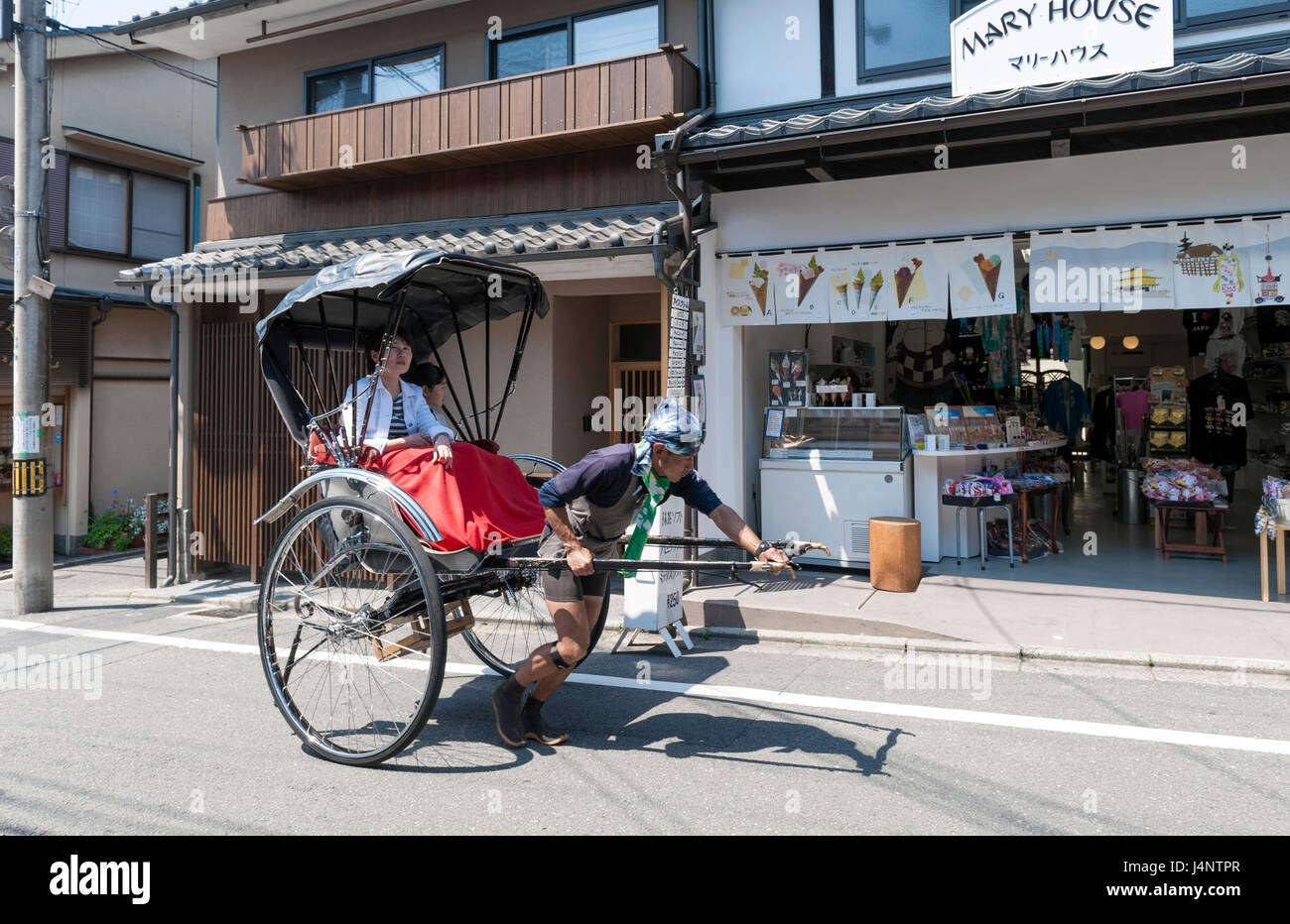 Kyoto, Giappone - Marzo 2016: Giapponese tradizionale tirata a mano rickshaw che trasportano i turisti su Matsubara street a Kyoto, Giappone Foto Stock