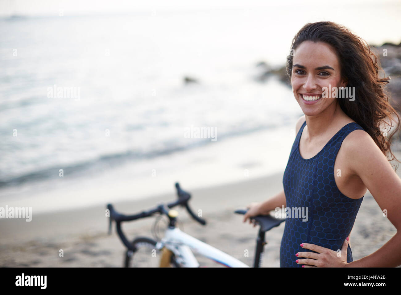 Un triatleta femmina sulla spiaggia che indossa la sua tuta triathlon Foto Stock