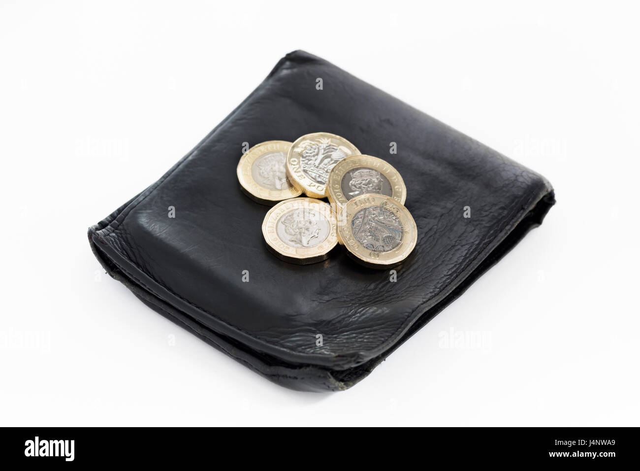 New British £1 monete sul portafoglio nero, sfondo bianco Foto Stock