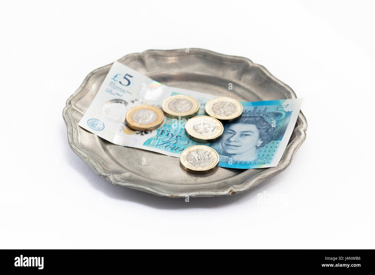 New British £1 monete e la nuova British £ 5 nota sul vassoio d'argento, sfondo bianco Foto Stock