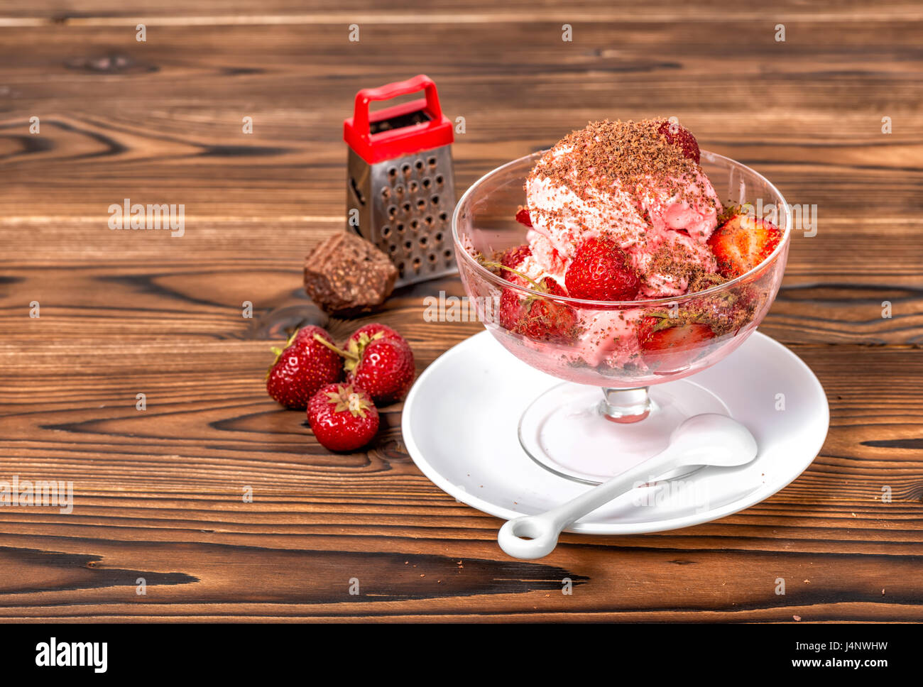 Stil life di dessert Fragola Rosa gelato alla vaniglia scoop con grattugia, Cioccolato e fragole fresche in vaso su sfondo di legno Foto Stock