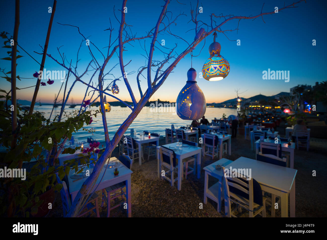 Informale salotto sulla spiaggia con zucca decorativa luci pendenti da un albero a bodrum, Turchia Foto Stock