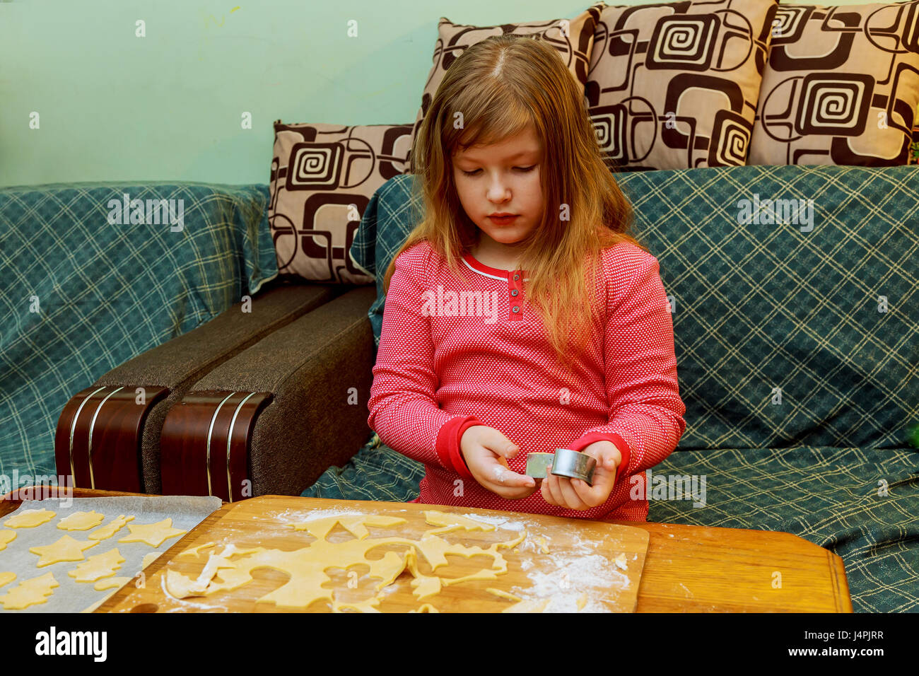 Felice ragazza con la sindrome di Down cuoce i cookies bambino rendendo torta Foto Stock