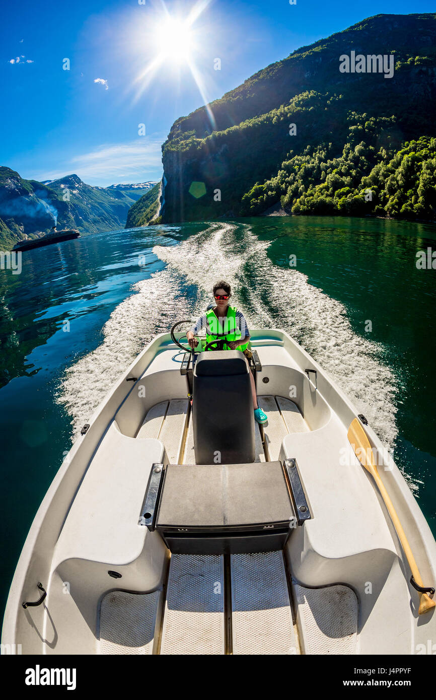 Donna alla guida di una barca a motore. Geiranger fjord, la bellissima natura della Norvegia.La vacanza estiva. Foto Stock