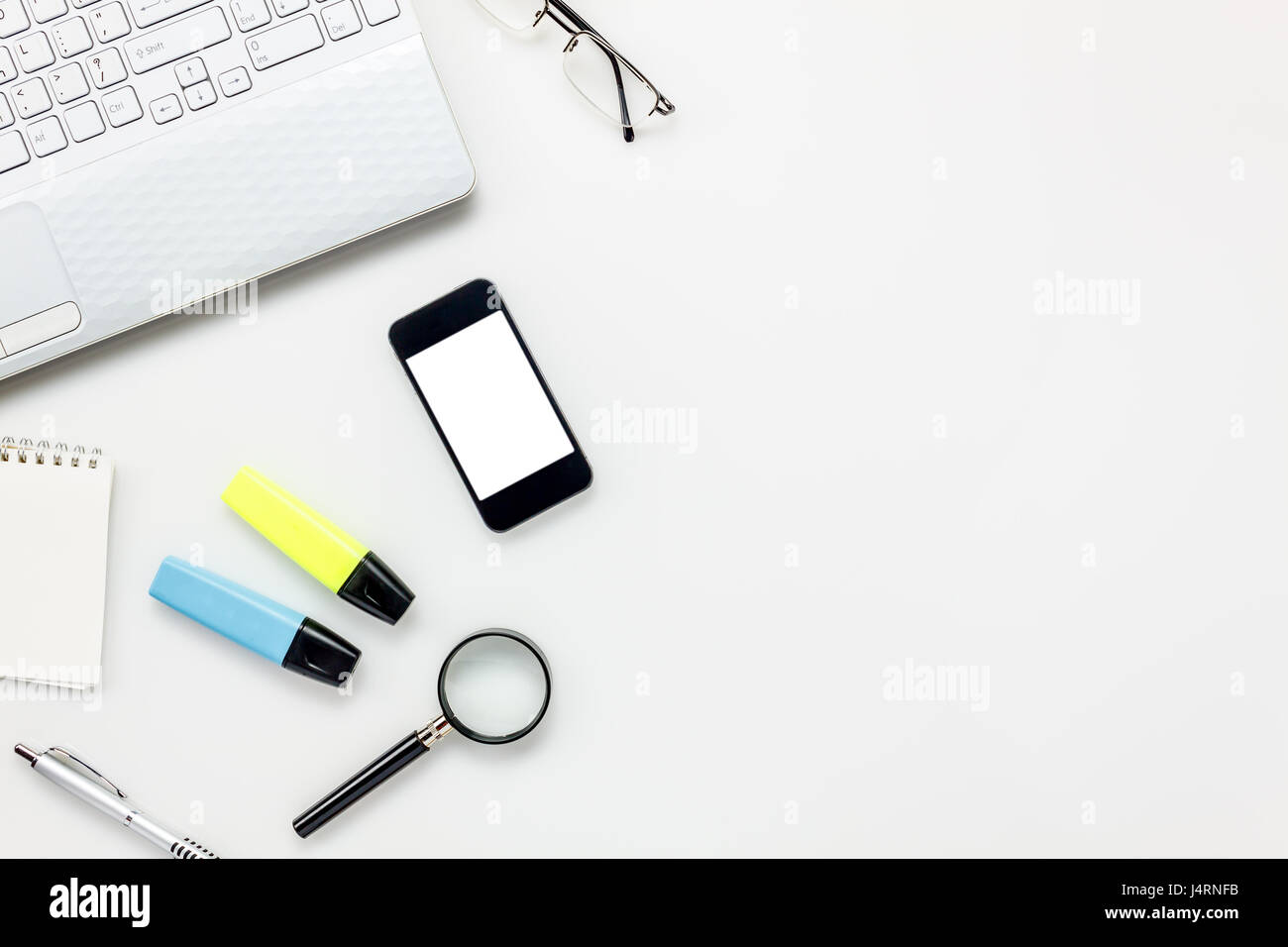 Top Visualizza accessori ufficio concetto.telefono mobile,notepaper,pen,laptop,occhiali su bianco scrivania in ufficio. Foto Stock