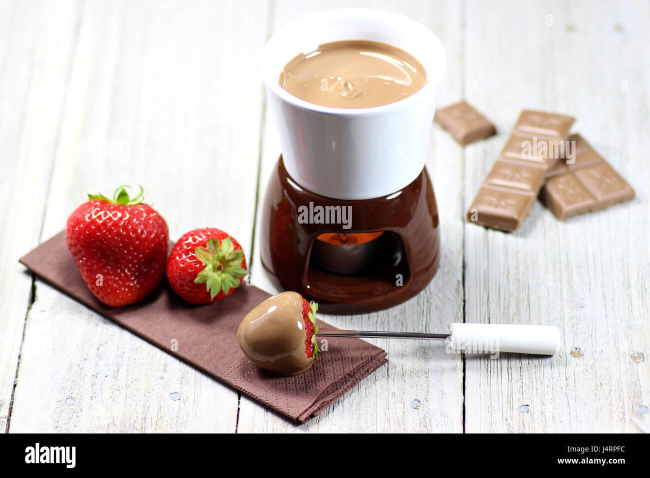 La Fonduta di cioccolato con fragole su sfondo di legno Foto Stock