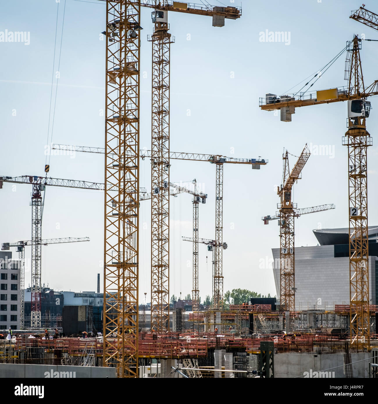 Molte gru e lavoratori edili sulla grande sito in costruzione Foto Stock