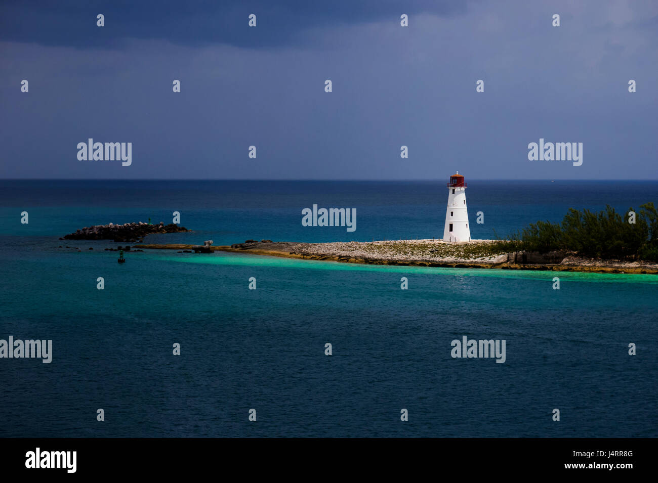 Sun Lit faro bianco su un giorno di tempesta in un'isola Foto Stock