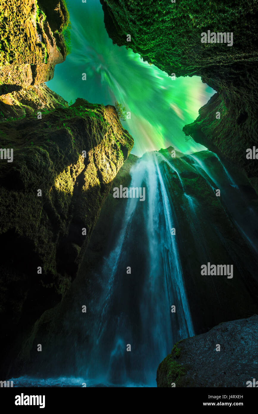 Green aurora luce dietro un unico Gljufrabui cascata in grotta. L'Islanda, l'Europa. La cortesia della NASA. Photo Collage Foto Stock
