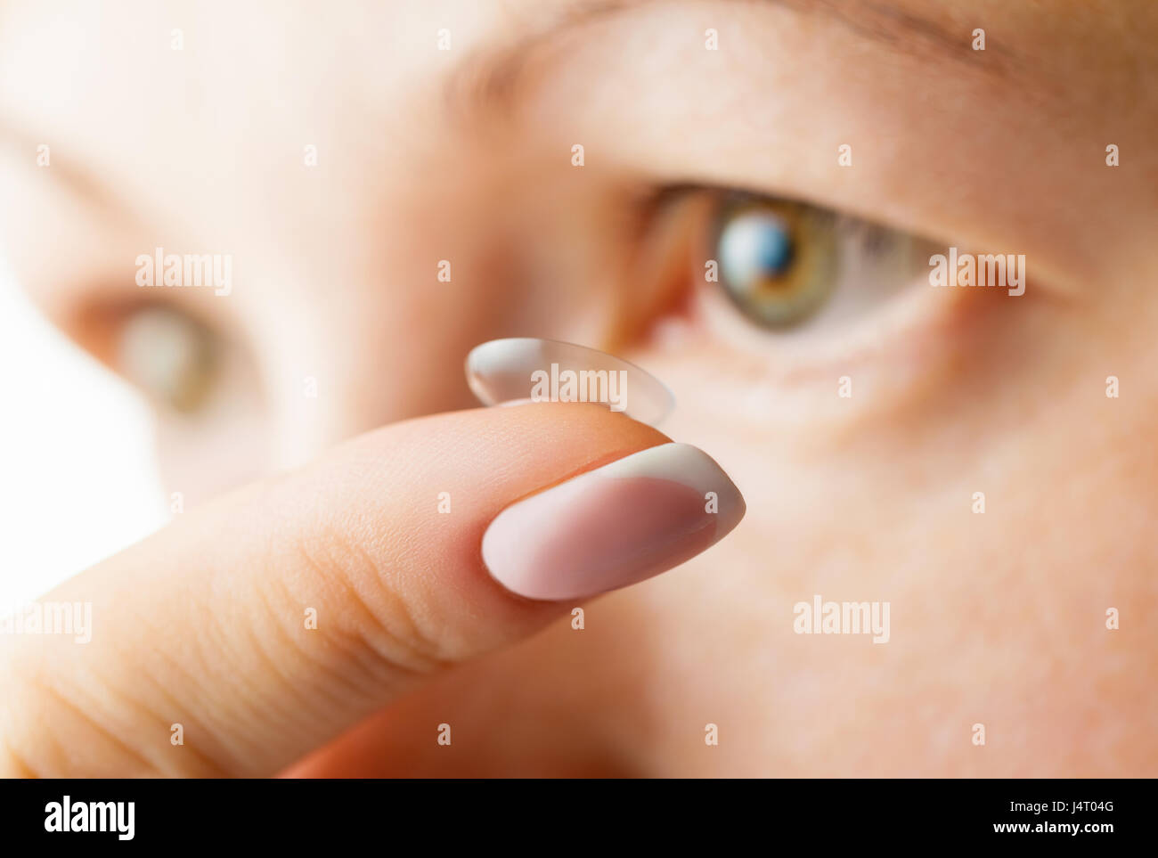 Occhio femmina e la lente a contatto. Focus sul dito Foto Stock