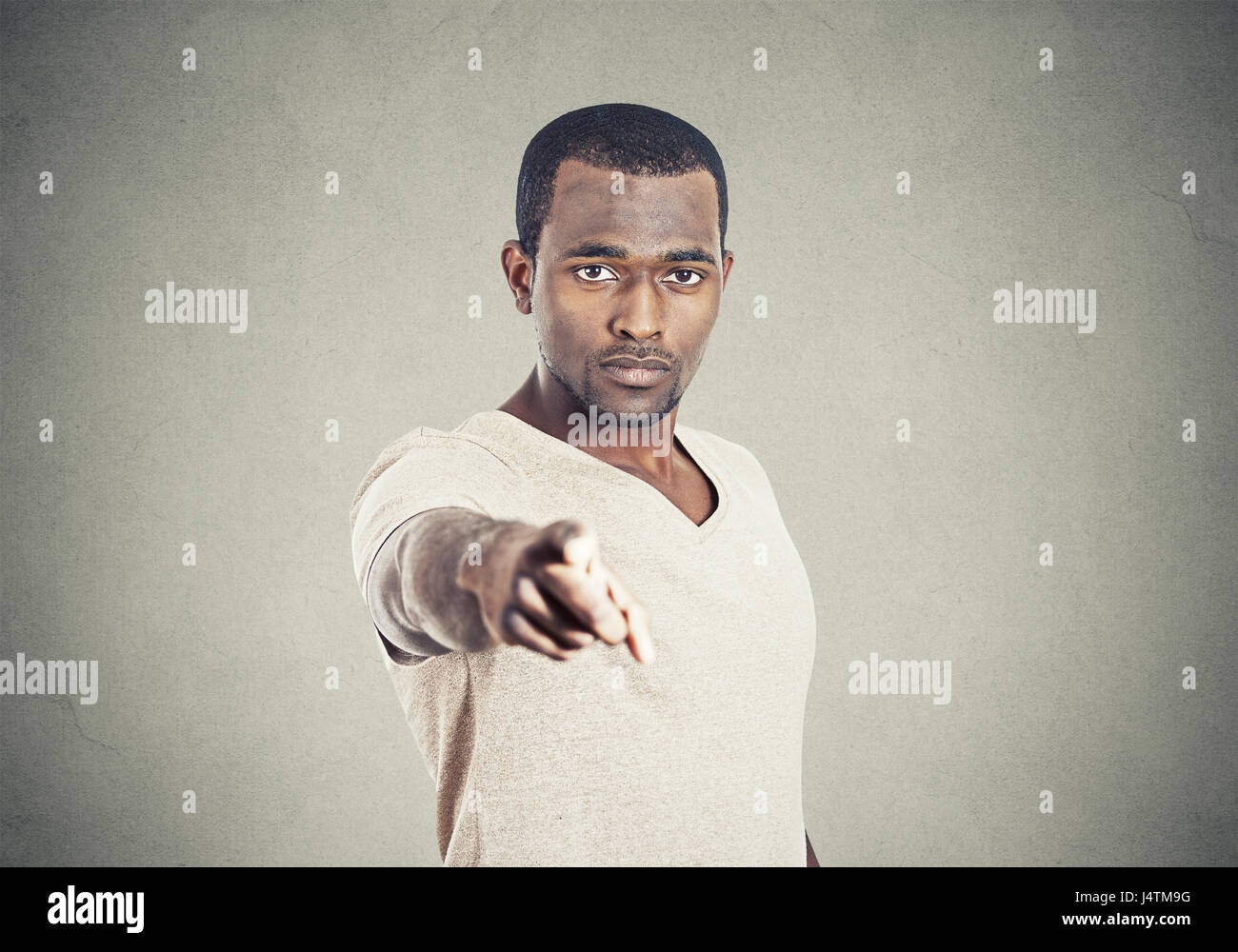 Closeup ritratto uomo rivolto a voi con il dito indice isolato sul muro grigio Sfondo. Foto Stock