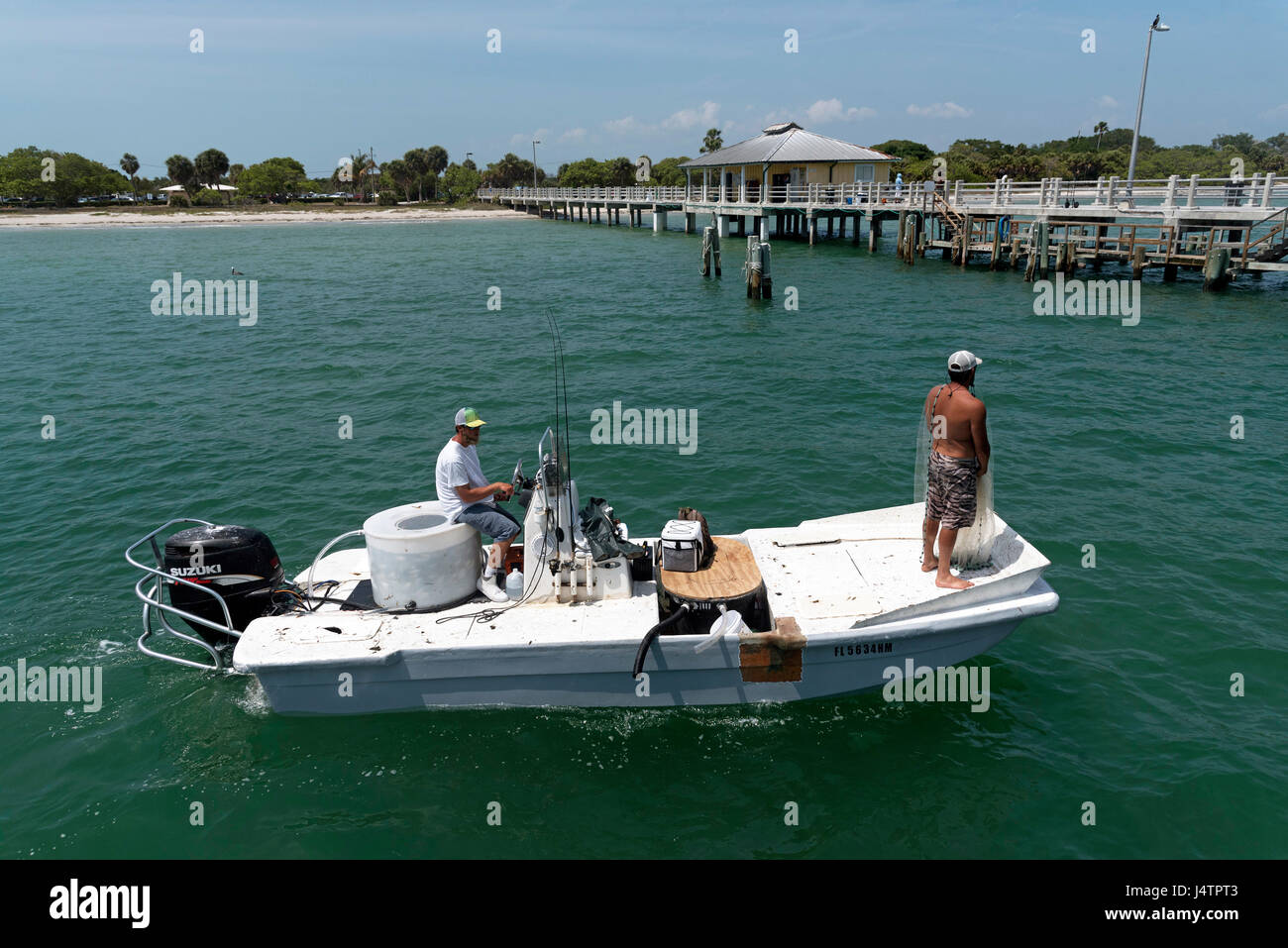 La pesca di queste esche utilizzando un cast net da una piccola barca sul Golfo del Messico in Florida USA Foto Stock