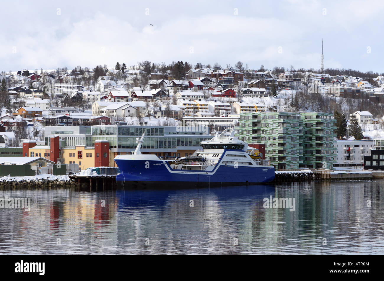 Il blu dipinto di vettore di pesce nave Ro Arctic presso la banchina con la città di Tromso dietro di esso. Tromsø, Troms, Norvegia. Foto Stock