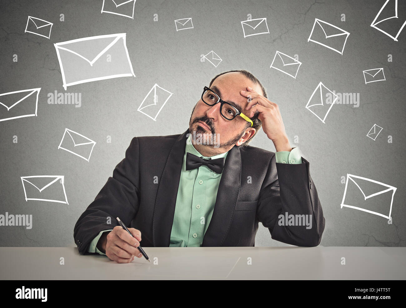 Considerato business uomo seduto a tavola in attesa di cambiare la vita di lavoro di posta elettronica intervista lettera ufficio isolato muro grigio Sfondo spazio copia. F umana Foto Stock