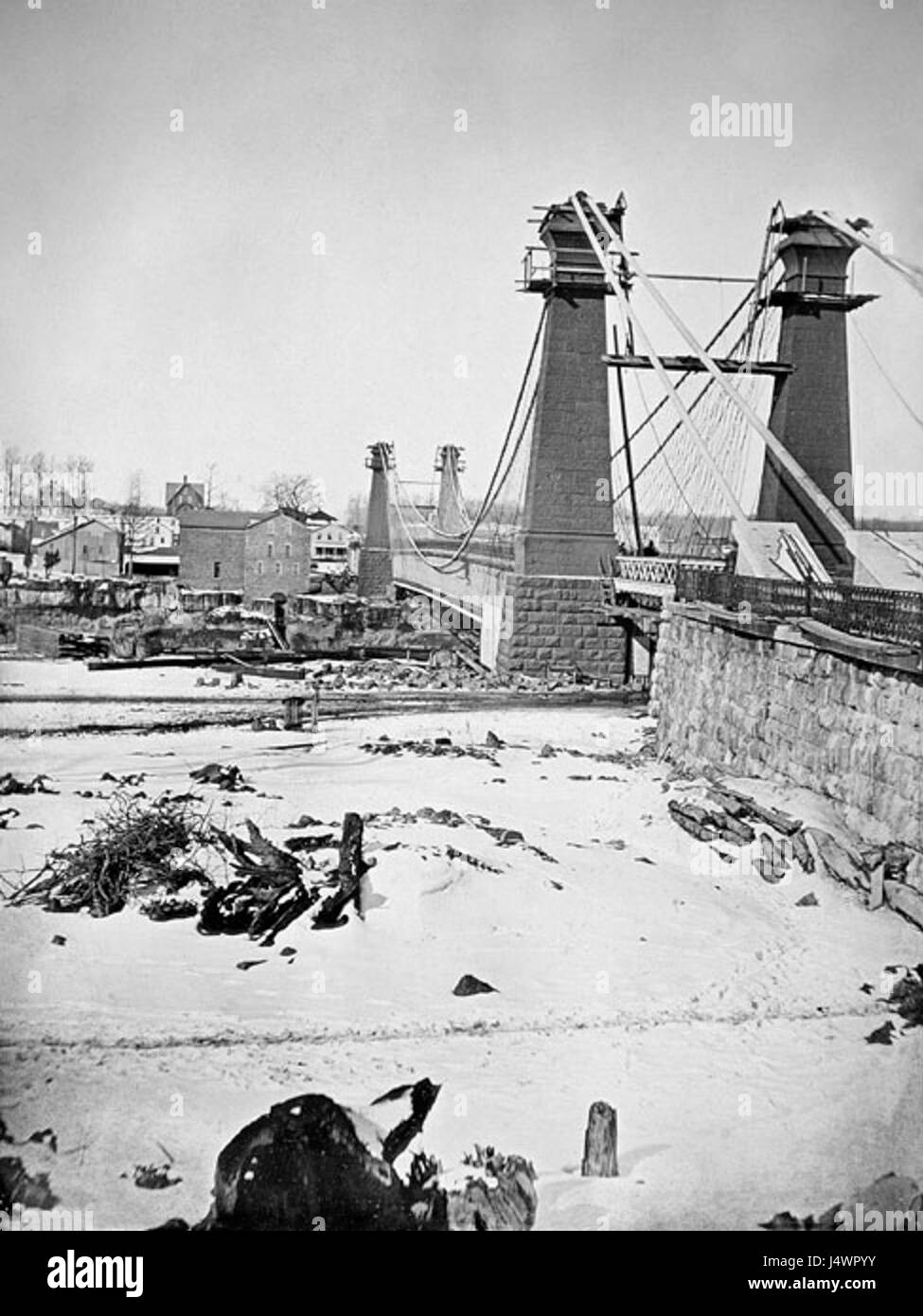 Questa fotografia cattura la stagione invernale presso il Niagara Suspension Bridge, mostrando il paesaggio innevato che circonda l'iconica struttura. Il ponte è un importante punto di riferimento storico che collega New York e il Canada. Foto Stock