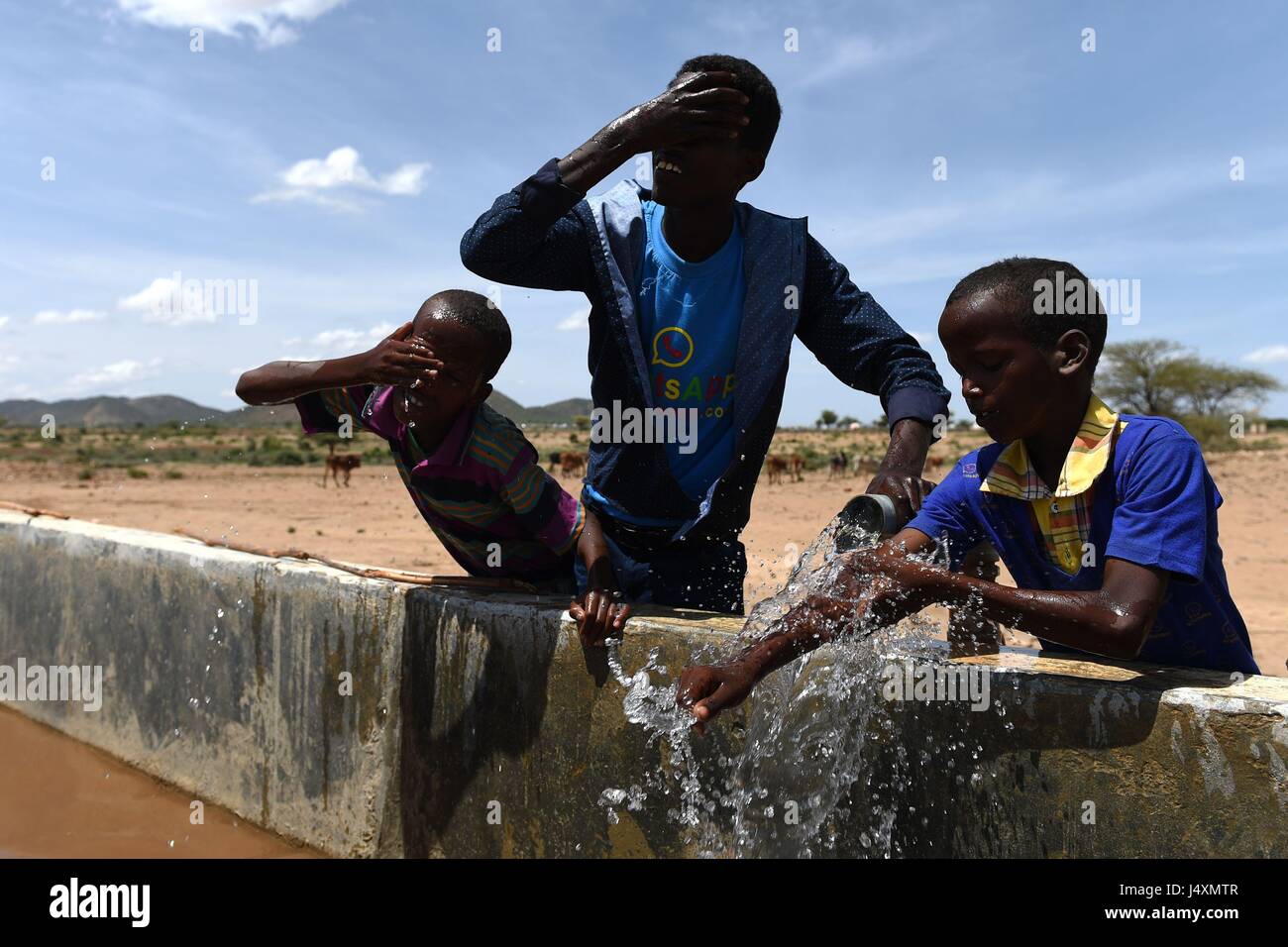 Bambini lavare con acqua da una pipeline n il villaggio di Afraaga, il Somaliland dove la carità CARE International hanno costruito un serbatoio di stoccaggio e installato gli oleodotti e i rubinetti a dare gli abitanti di un villaggio di accesso all acqua pulita da un foro di trivellazione nelle vicinanze. Foto Stock