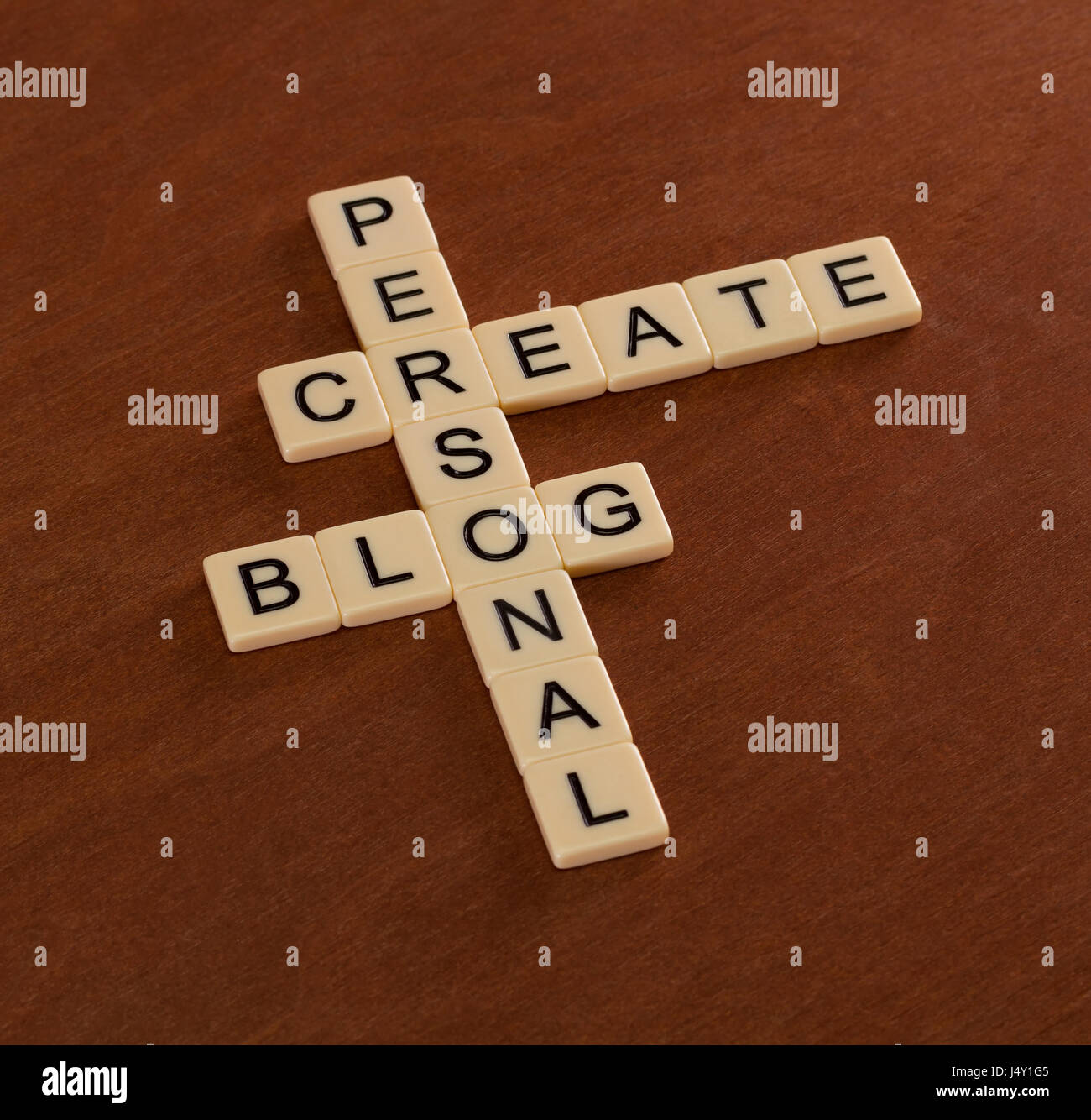 Cruciverba con parole creare blog personale. Social networking concetto. Piastrelle color avorio con lettere maiuscole sulla scheda di mogano. Foto Stock