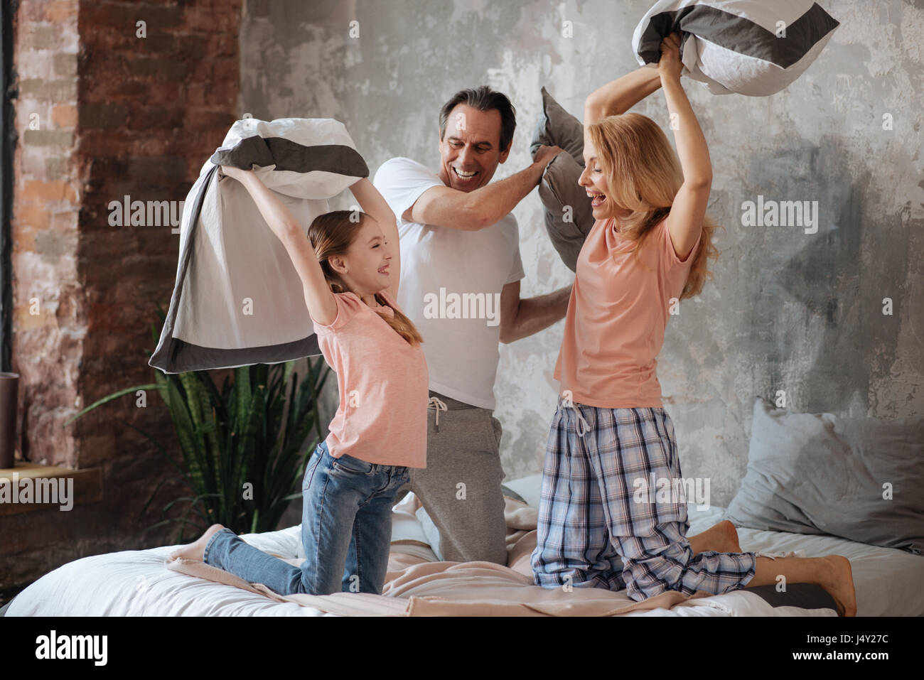 Famiglia divertito godendo cuscino lotta in casa Foto Stock